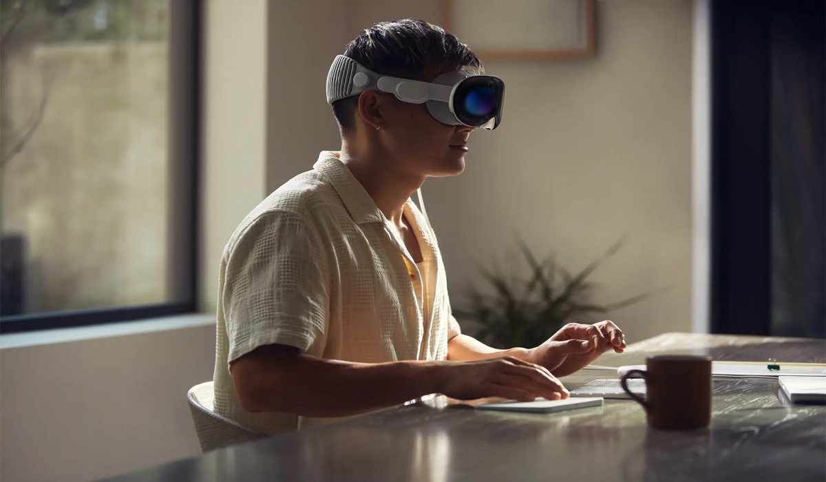 Apple Vision Pro being worn by a person while using a keyboard
