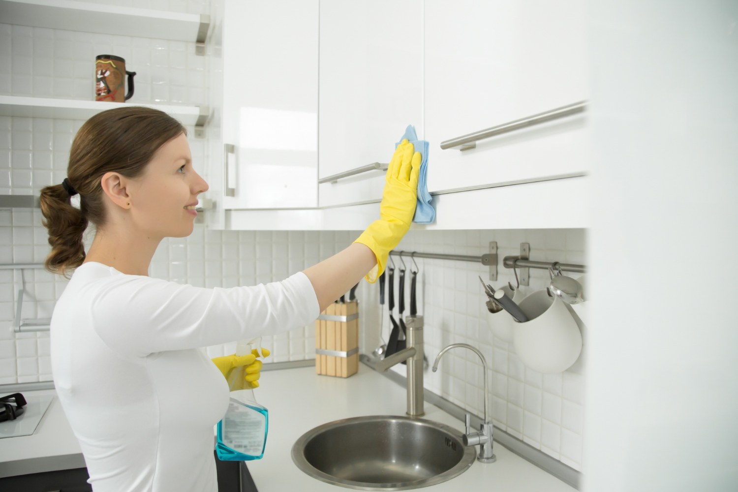 profile portrait attractive woman cleaning white kitchen clos